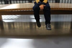 child sitting on bench waiting