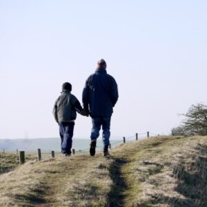 Father and son walking together on a footpath